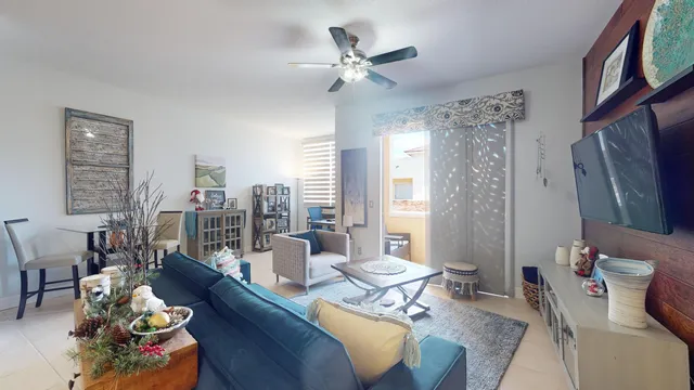 a living room with furniture kitchen view and a large window