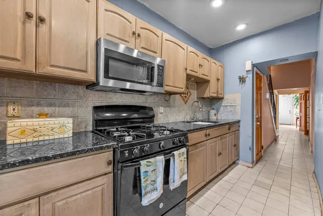 a kitchen with stainless steel appliances granite countertop a stove a sink and a microwave