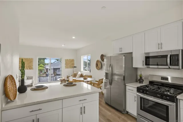a kitchen with stainless steel appliances a stove a sink a refrigerator and cabinets