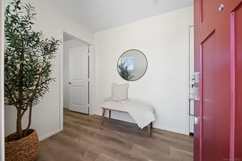 a view of a bedroom with wooden floor and a potted plant