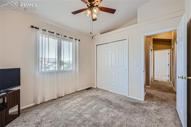 12510 Motley Road Peyton, CO 80831 - Photo 21 of 36 Unfurnished bedroom with vaulted ceiling, carpet, a closet, and ceiling fan