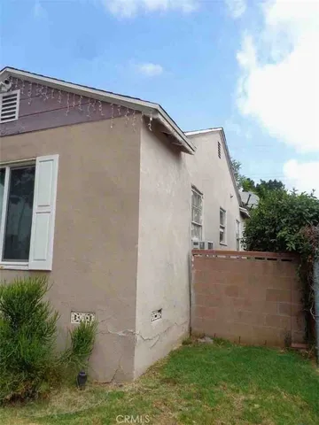 a backyard of a house with lots of plants and entertaining space