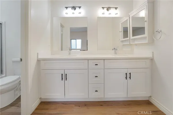 a bathroom with a sink a toilet and mirror