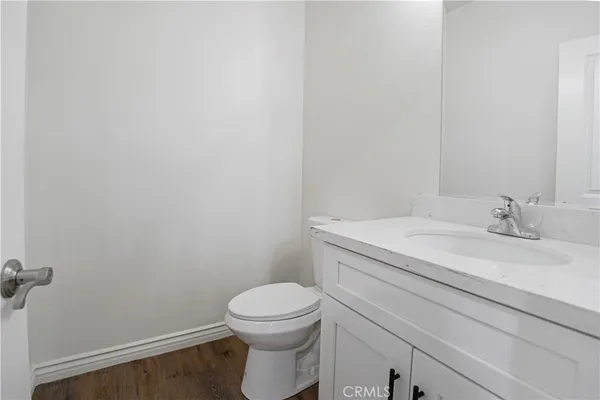 a bathroom with a granite countertop toilet and a sink