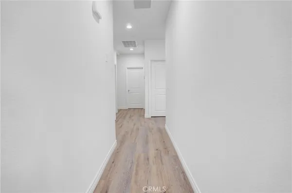 a view of a hallway with wooden floor