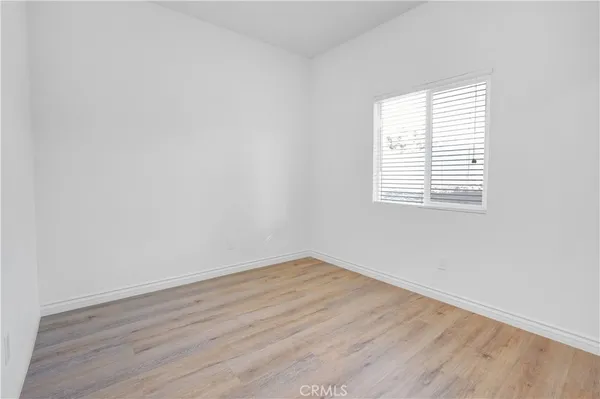 an empty room with wooden floor and a window