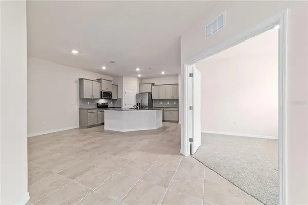 a view of kitchen with kitchen island and stainless steel appliances