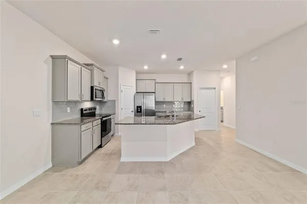 a large kitchen with a stove a sink and a refrigerator