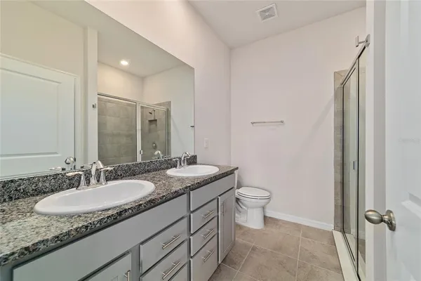 a bathroom with a granite countertop sink a toilet and a mirror