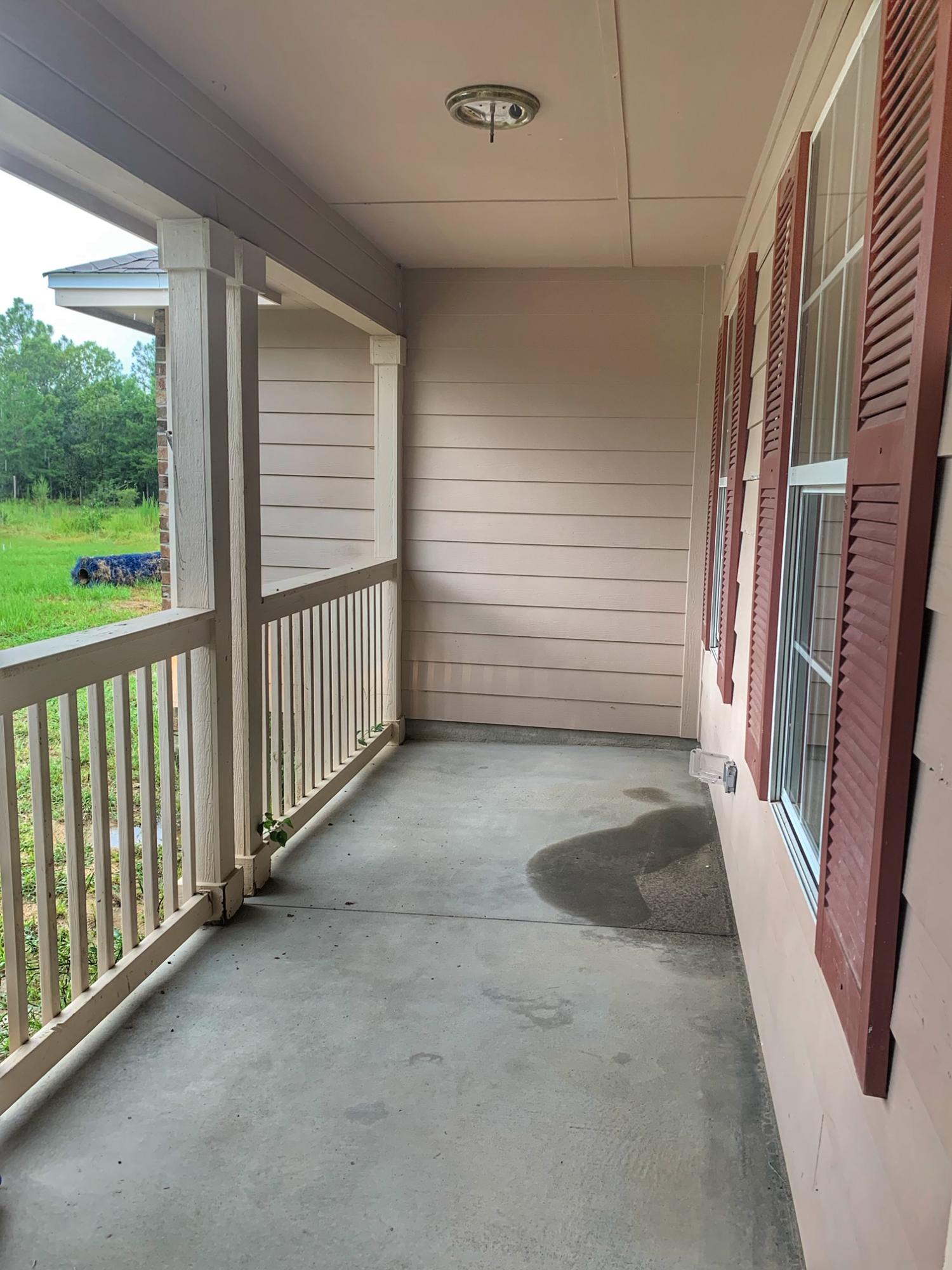 657 Elmwood Road DeFuniak Springs, FL 32433 - Photo 4 of 15 a view of a porch with wooden floor and stairs
