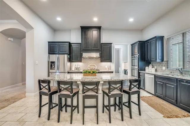 a kitchen with kitchen island cabinets and chairs in it