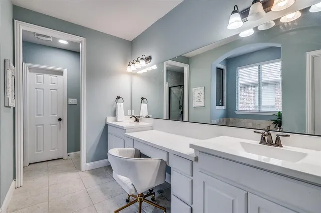 a bedroom with a bed a chandelier with a dresser and a chandelier