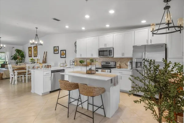 a kitchen with a refrigerator and a stove top oven