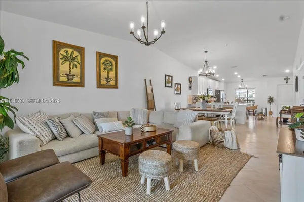 a living room with furniture a chandelier and a dining room