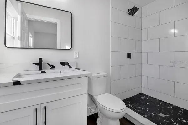 a bathroom with a toilet a sink and mirror