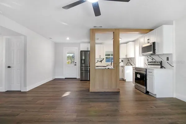 a view of kitchen with refrigerator stove microwave and cabinets