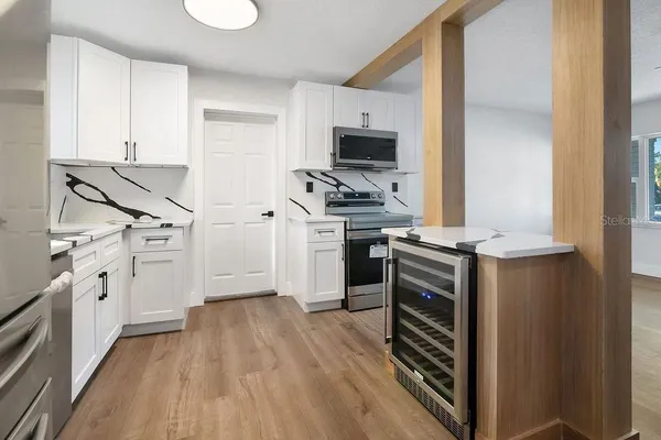 a kitchen with wooden floor and white appliances