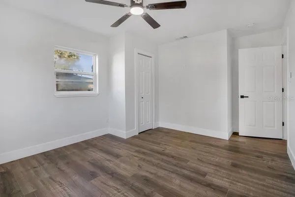 a view of an empty room with wooden floor