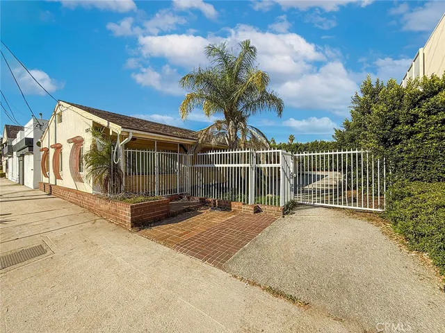 a view of a house with a wooden fence