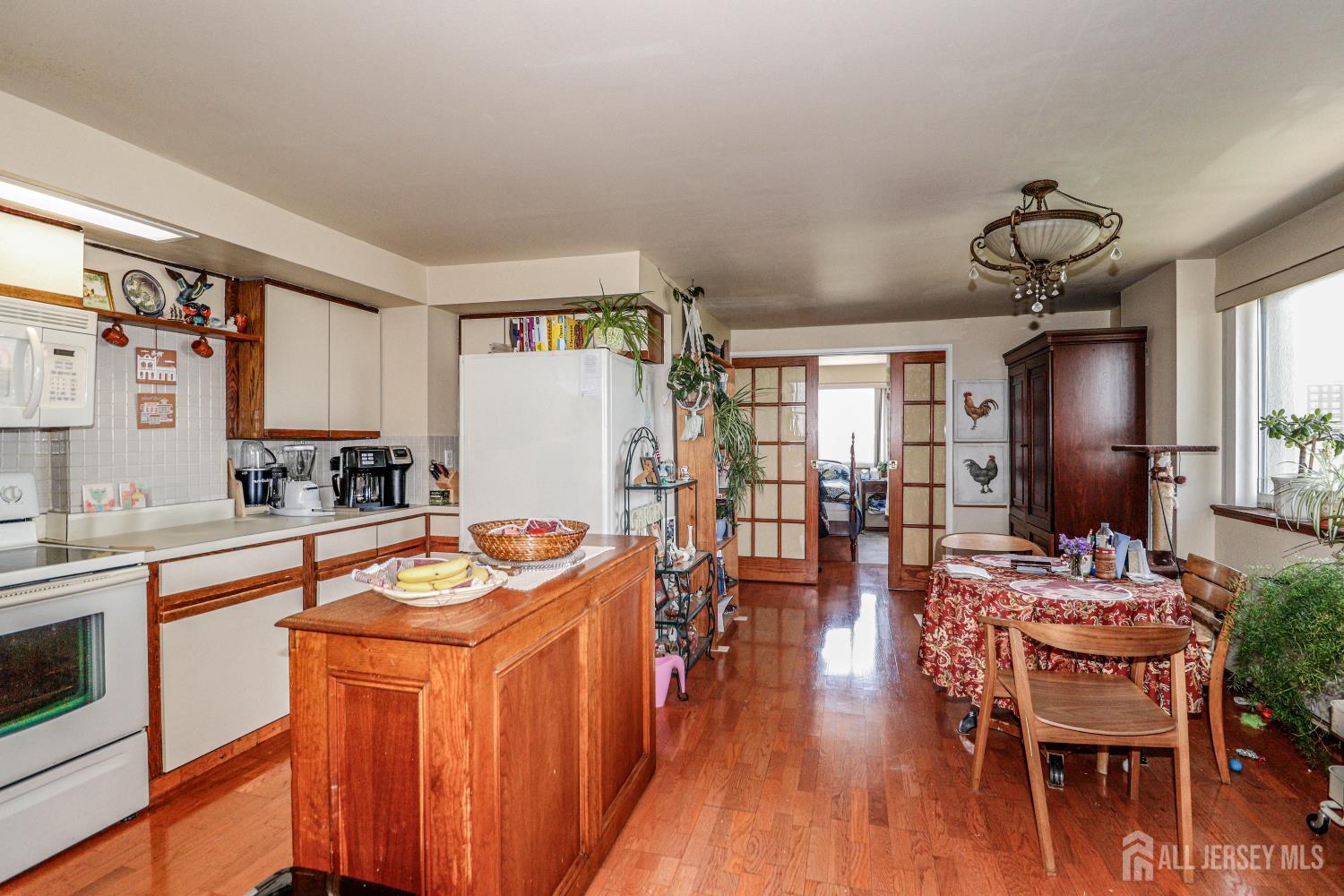 40 Fayette Street, Unit 57 Perth Amboy, NJ 08861 - Photo 1 of 33 a dining hall with stainless steel appliances granite countertop a stove a sink dishwasher a dining table and chairs with wooden floor