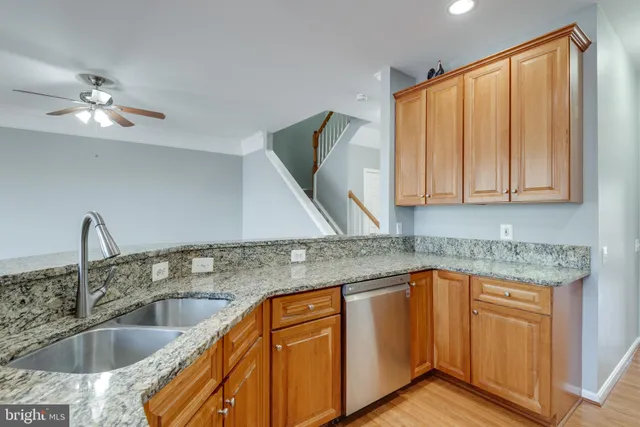 a kitchen with stainless steel appliances granite countertop a sink a granite counter tops and a wooden floors