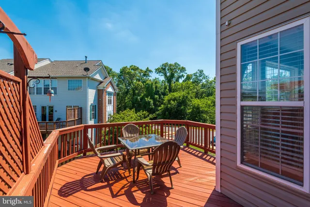 a view of a patio with table and chairs with wooden floor and fence