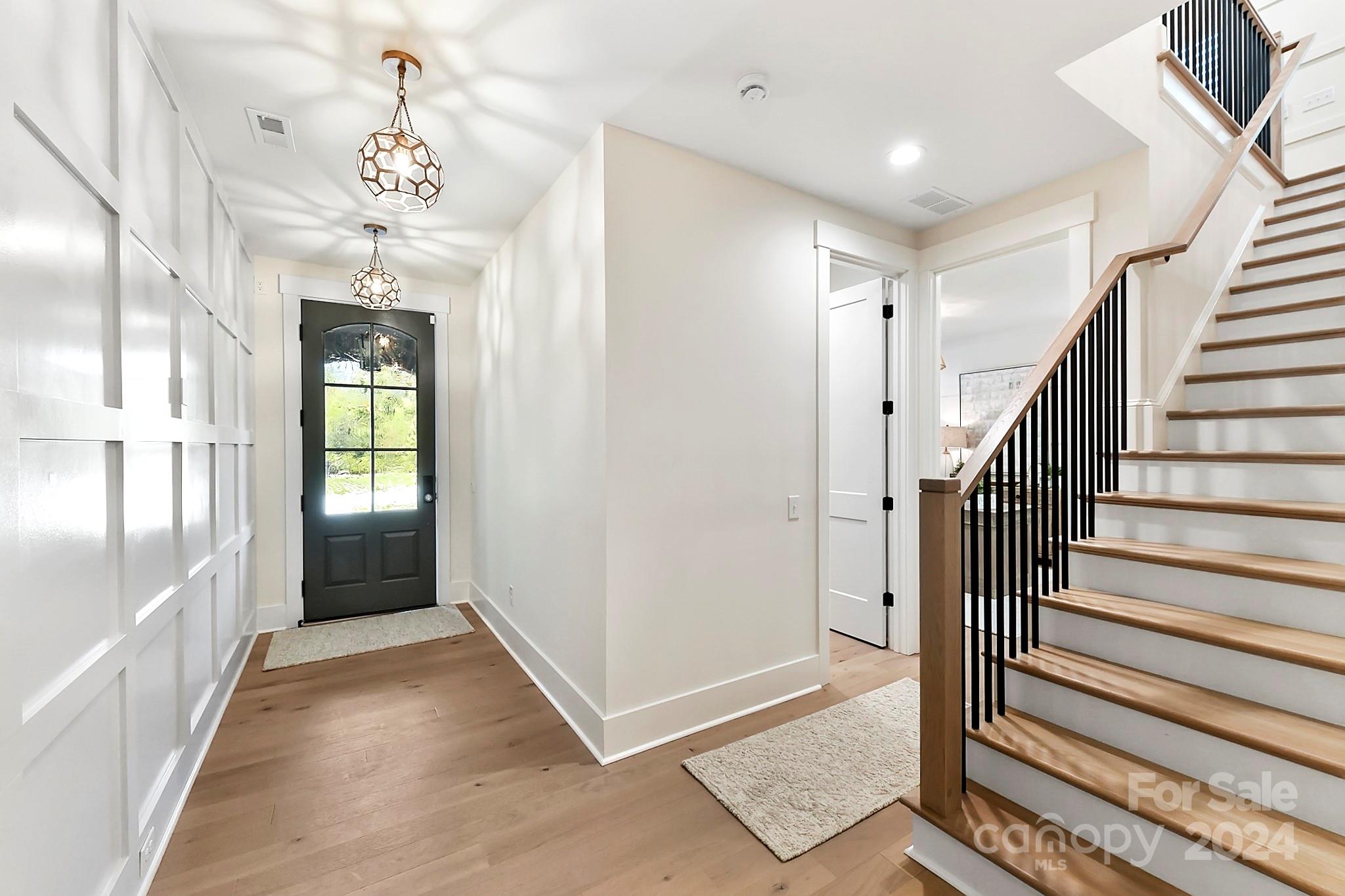 335 Bubbling Well Road Matthews, NC 28105 - Photo 4 of 48 a view of a hallway with wooden floor and stairs