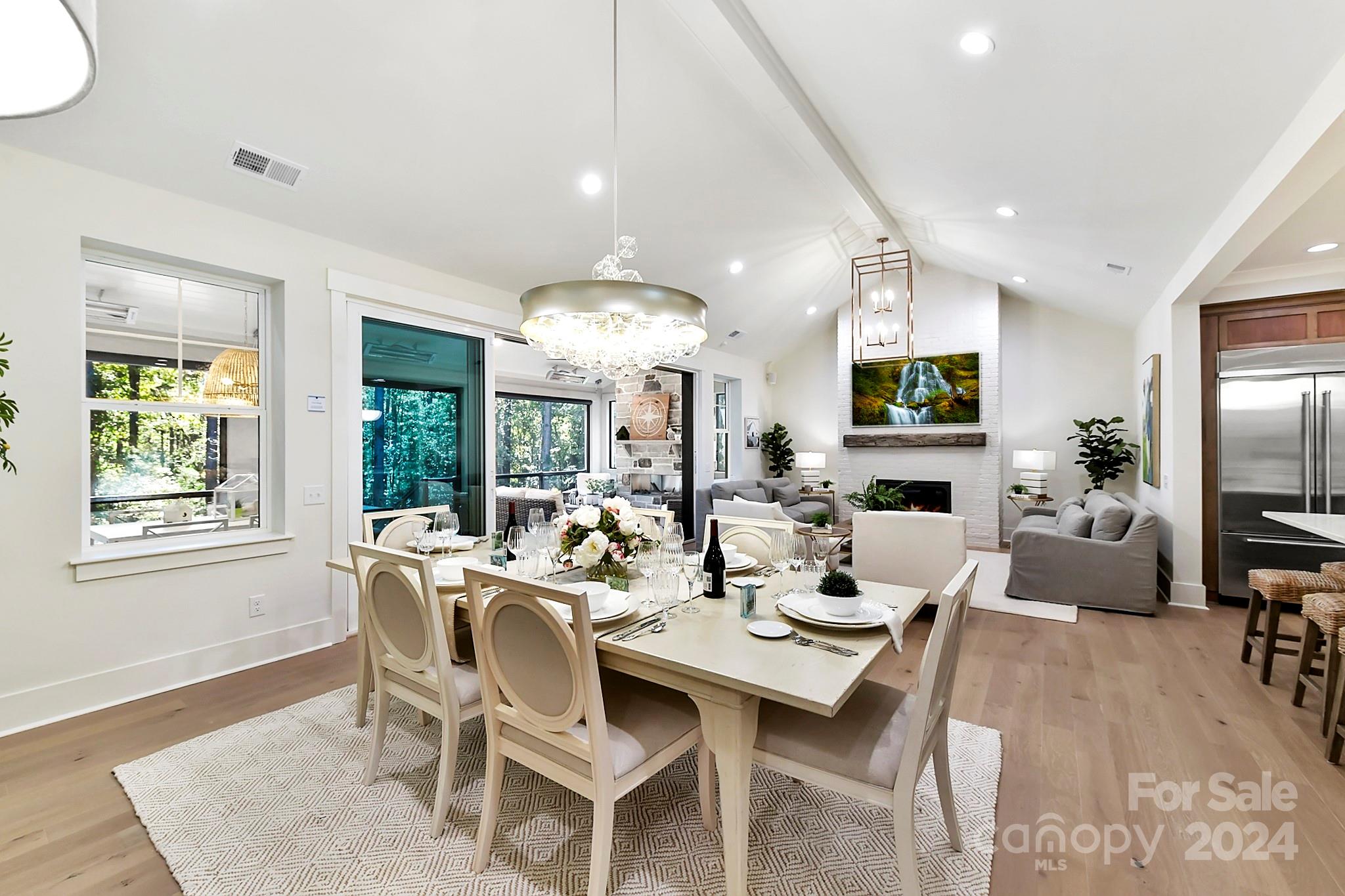 335 Bubbling Well Road Matthews, NC 28105 - Photo 10 of 48 a dining room with wooden floor a chandelier a glass table and chairs