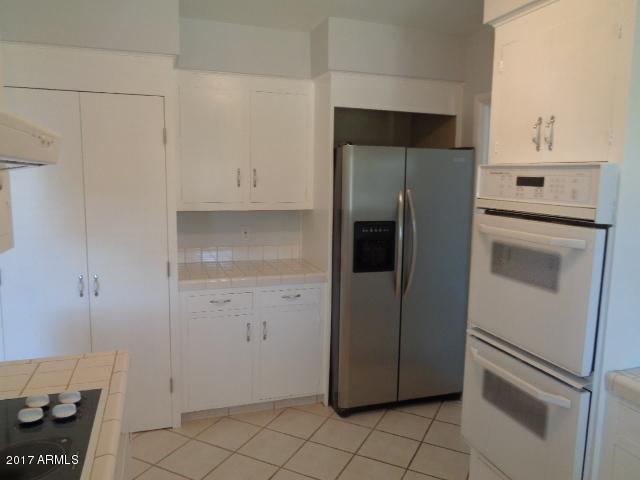 3424 East Camelback Road Phoenix, AZ 85018 - Photo 21 of 27 a kitchen with a refrigerator and a stove