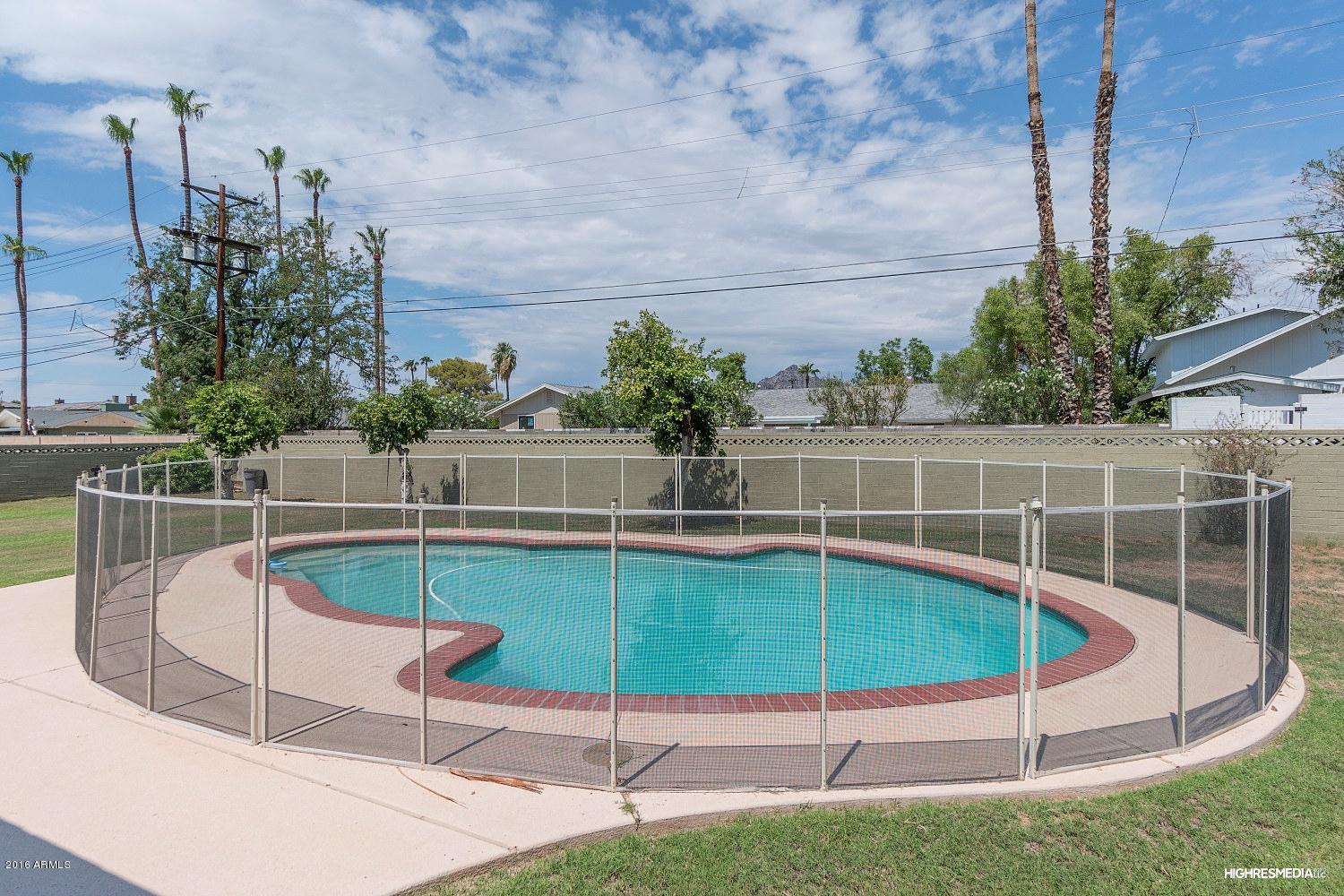 3424 East Camelback Road Phoenix, AZ 85018 - Photo 26 of 27 a view of a swimming pool with a chair and tables in the back yard