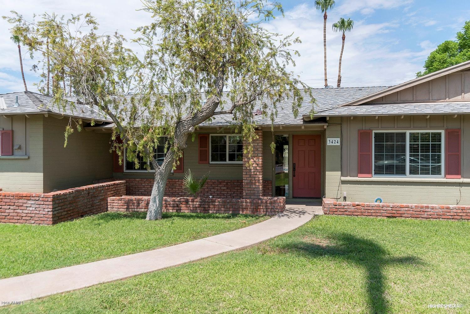 3424 East Camelback Road Phoenix, AZ 85018 - Photo 3 of 27 a front view of a house with a yard table and chairs