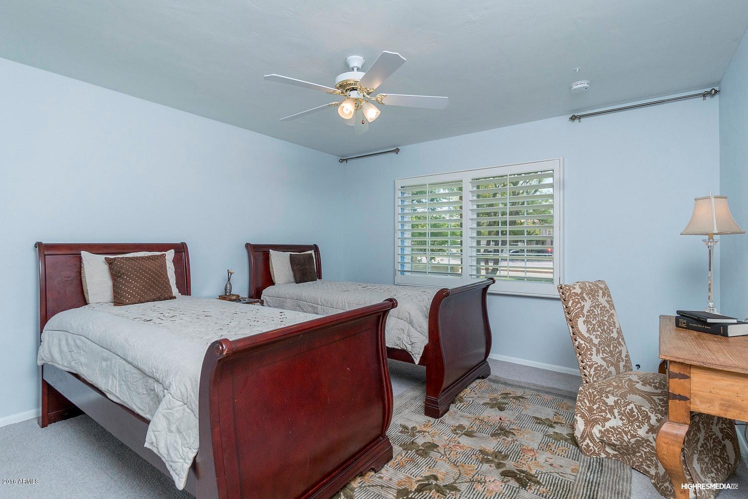 3424 East Camelback Road Phoenix, AZ 85018 - Photo 9 of 27 a bedroom with a bed a chair and a chandelier