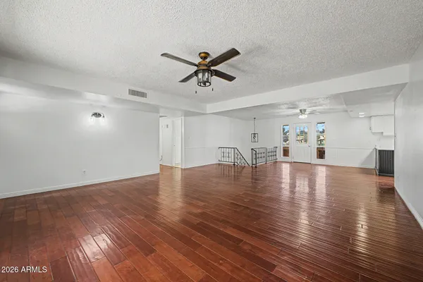 a view of an empty room with wooden floor