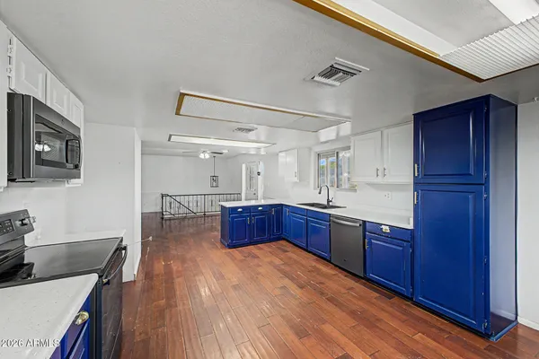 a kitchen with stainless steel appliances granite countertop a stove and a wooden floors