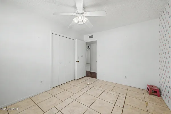 a view of an empty room with wooden floor and window