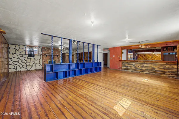 a view of a livingroom with wooden floor and a ceiling fan