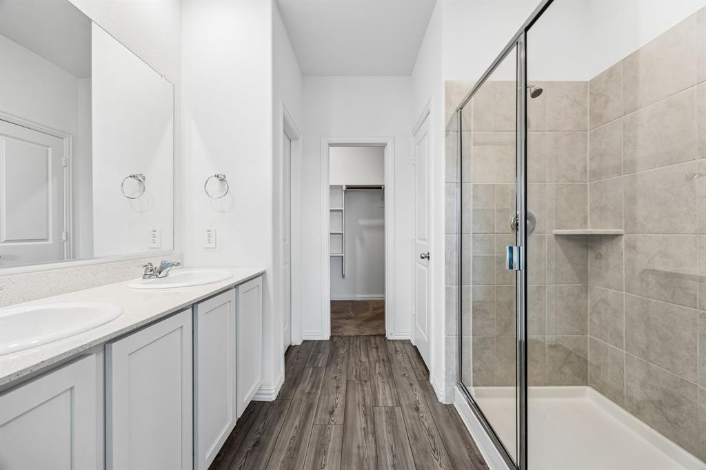 820 Carmen Street Forney, TX 75126 - Photo 15 of 25 a bathroom with a sink a mirror and a shower