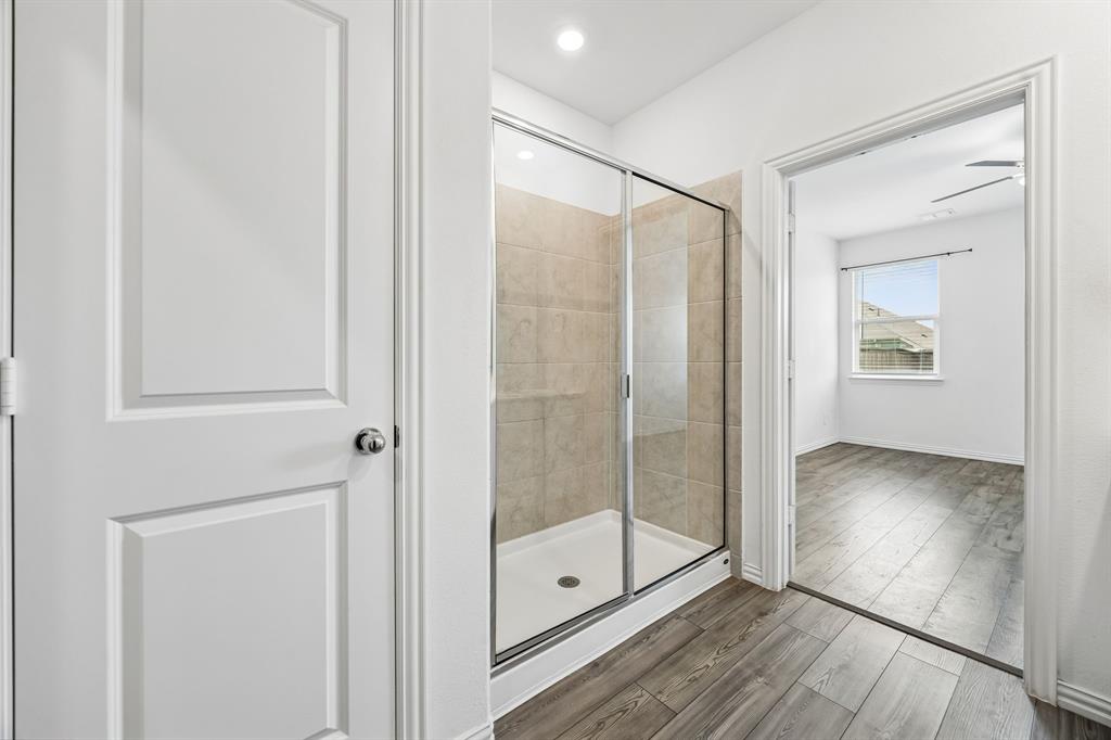 820 Carmen Street Forney, TX 75126 - Photo 17 of 25 a bathroom with a glass shower door and a window
