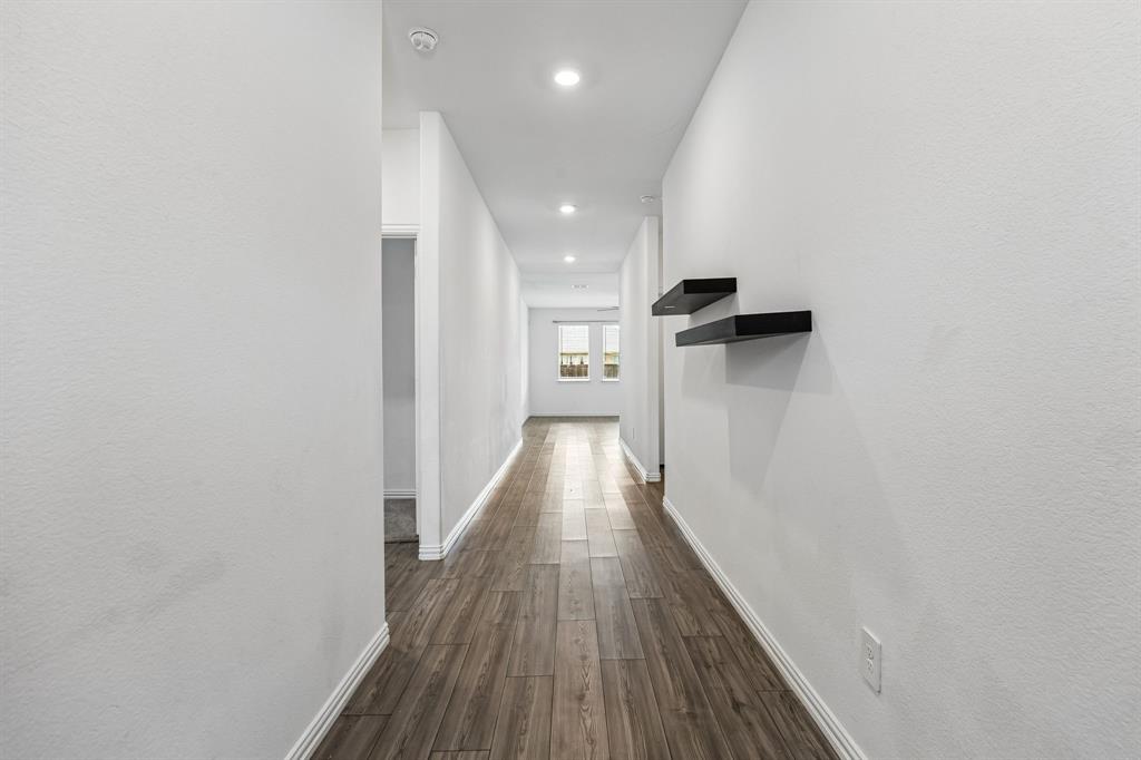 820 Carmen Street Forney, TX 75126 - Photo 2 of 25 a view of a hallway with wooden floor and staircase