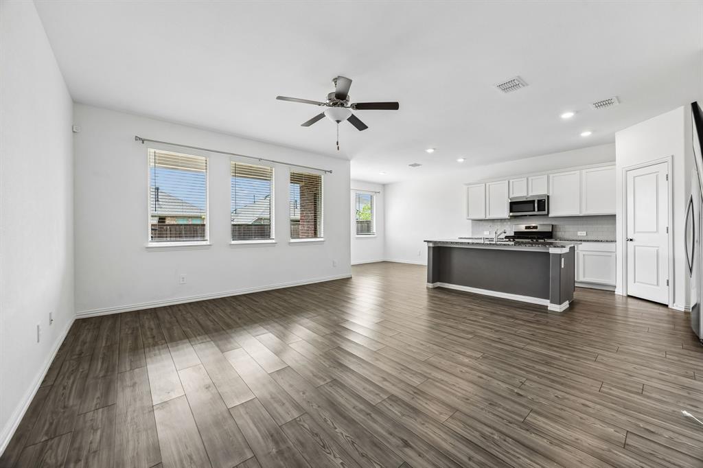 820 Carmen Street Forney, TX 75126 - Photo 4 of 25 a view of an empty room with wooden floor and a window