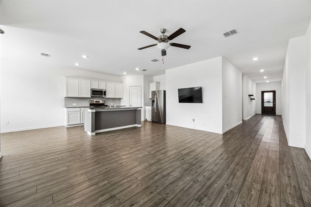 820 Carmen Street Forney, TX 75126 - Photo 5 of 25 a view of a kitchen with a stove cabinets and wooden floor