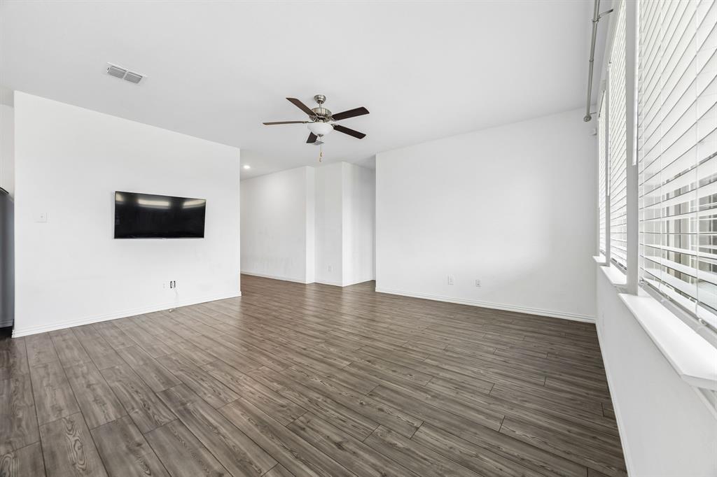 820 Carmen Street Forney, TX 75126 - Photo 6 of 25 a view of a livingroom with wooden floor and a flat screen tv