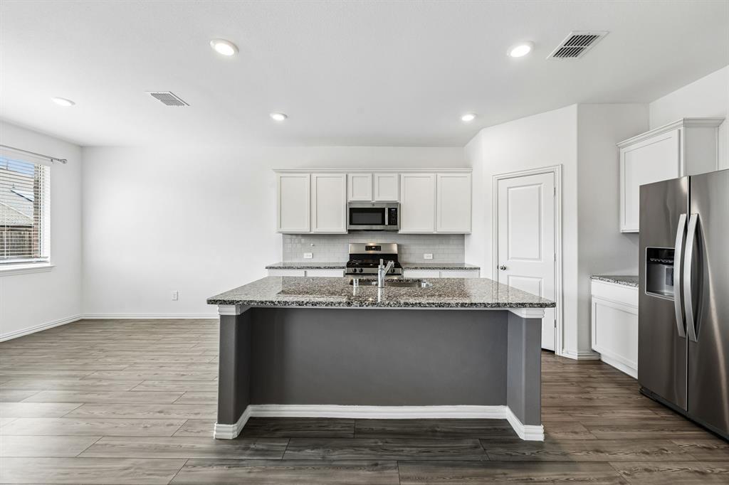 820 Carmen Street Forney, TX 75126 - Photo 9 of 25 a kitchen with stainless steel appliances granite countertop a sink stove and refrigerator