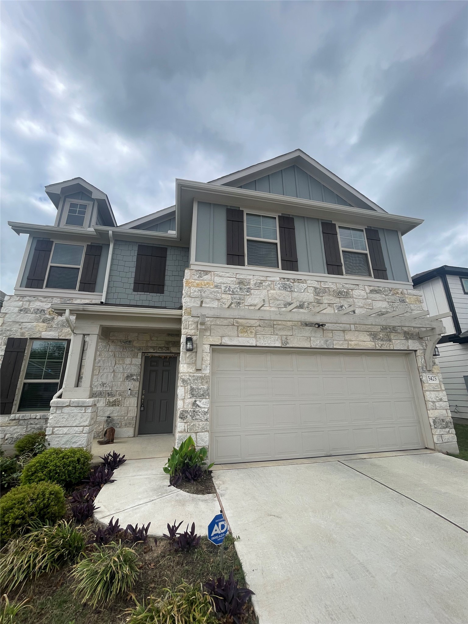 5425 Durango Pass Austin, TX 78724 - Photo 2 of 31 View of front of property with concrete driveway, stone siding, board and batten siding, and an attached garage