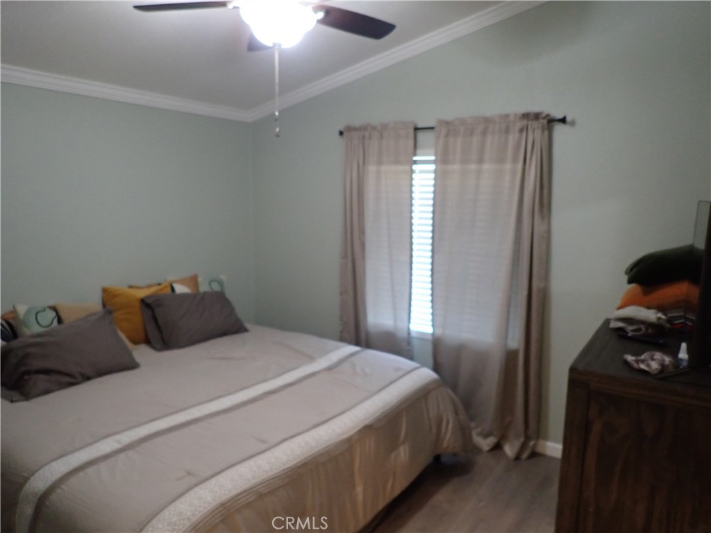 27250 Murrieta Road, Unit 386 Menifee, CA 92586 - Photo 15 of 32 a bedroom with a bed and a chandelier