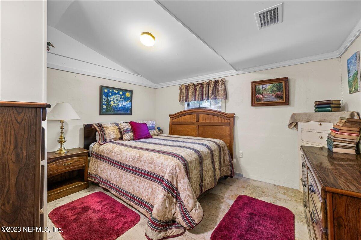 121 Peniel Church Road Palatka, FL 32177 - Photo 51 of 81 a bedroom with a bed and a chandelier