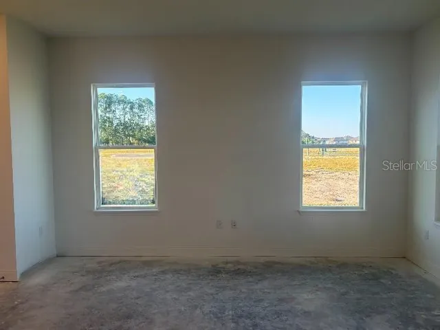 a view of empty room with window and chandelier