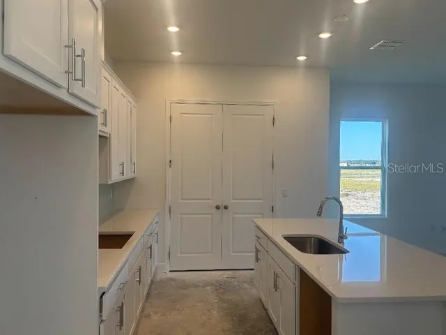 a large kitchen with stainless steel appliances granite countertop a sink a stove and a refrigerator