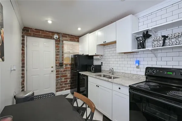 a kitchen with stainless steel appliances a stove a sink a refrigerator a cabinets and wooden floor