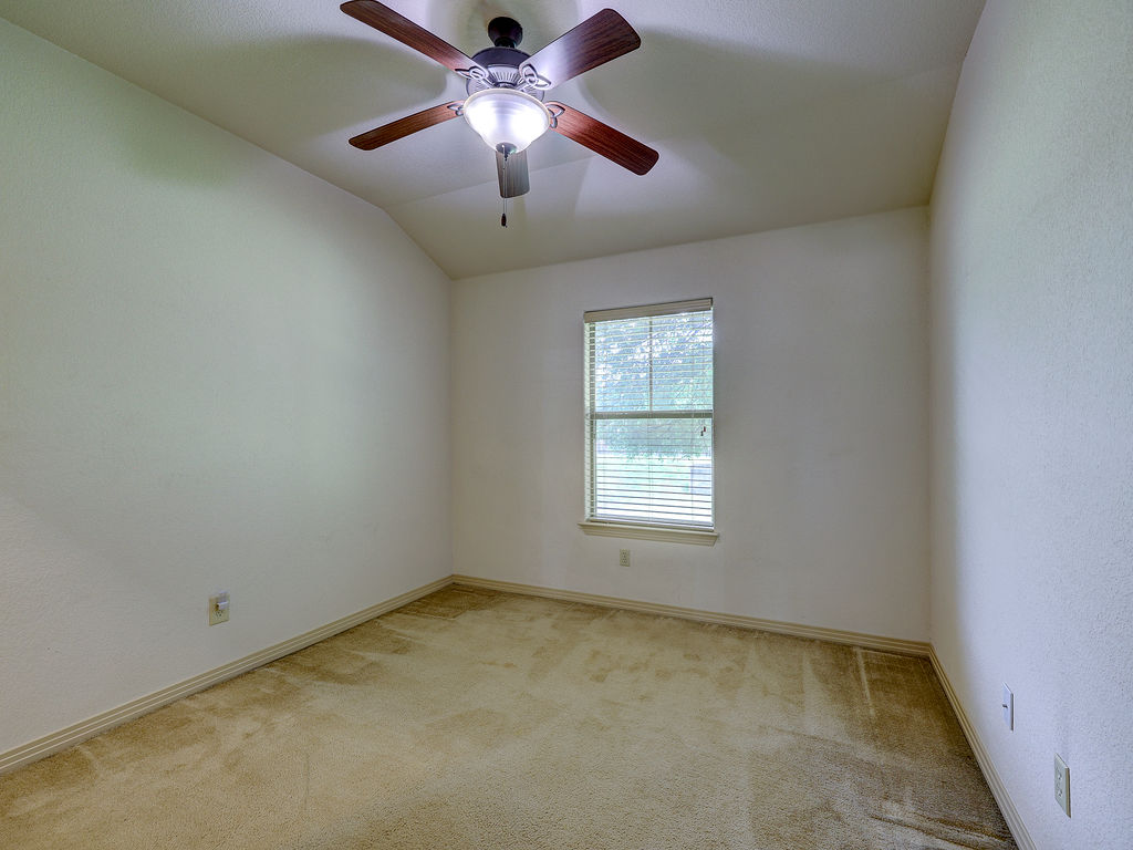 9707 Anderson Mill Road, Unit 22 Austin, TX 78750 - Photo 24 of 39 Well-lit room featuring vaulted ceilings and comfortable carpeting.
